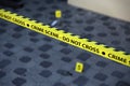 Crime scene tape for covering the area cordon. Yellow tape with blurred forensic law enforcement background in cinematic tone Royalty Free Stock Photo