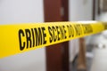 Crime scene tape in front room door with blurred background Royalty Free Stock Photo