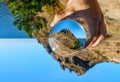 Crimea, Black Sea. Scenic landscape of Karadag mountain viewed thru glass ball in hand on sunny clear blue sky day. Mountain peak