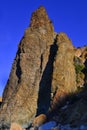 Crimea, Cape Fiolent, high sharp ancient basalt rock, cliff stands on Black Sea stones coast, in the light of sunset Royalty Free Stock Photo