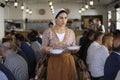 At the Crimean Tartar restaurant: waitress in Tartar native dress setting the table