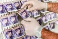 Criminal Hands In Gloves On British Sterling Pounds Notes On Clothes Dryer. Money Laundering Concept