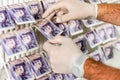 Criminal Hands In Gloves On British Sterling Pounds Notes On Clothes Dryer. Money Laundering Concept