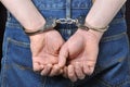 Criminal hands locked in handcuffs Royalty Free Stock Photo