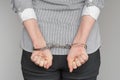 Criminal hands locked in handcuffs. Close-up view