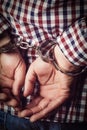 Criminal hands locked in handcuffs