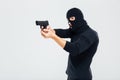 Criminal man in balaclava standing and aiming with gun Royalty Free Stock Photo
