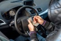 criminal man holding a large sum of dollar bills inside the car.