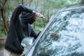 criminal man wearing black in street holding knife near car Royalty Free Stock Photo