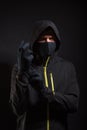 The criminal in the mask puts on a glove. Preparation for robbery Royalty Free Stock Photo