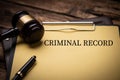 Criminal Record text on Document and gavel isolated on wooden office desk