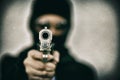 Criminal robber with aiming gun, Bad guy in hood.