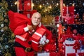 Criminal Santa Claus posing with a bag of christmas gifts. Criminal christmas. Funny bad Santa Claus with gift, bag with