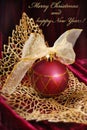 Crimson christmas bauble on golden openwork leaf Royalty Free Stock Photo