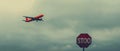 Crimson Contrasts: A Vibrant Red Airplane Soars Past a Grey Sky and Stop Sign