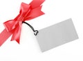 red ribbon with simple tied bow wrapped gift box corner with blank gray cardboard tag card for greeting message Royalty Free Stock Photo