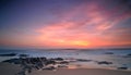 Crimson sky over rocky beach