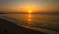 Crimson sunset on the seashore. Birds fly against the background of the rising sun. Morning on the beach.