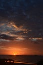 Crimson Tropical sunrise seascape with pink tinged dark nimbostratus cloud. Huay Yang, Thailand