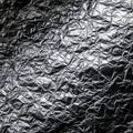 Crinkled aluminum foil with reflective, metallic surface. Random folds create complex Royalty Free Stock Photo