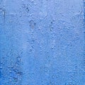 A crinkled blue painted wooden surface close up, vibrant monochrome textured background.