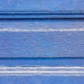 Crinkled bright blue painted wooden surface close up, vibrant monochrome texture.