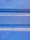 Crinkled bright blue painted wooden surface close up, vibrant monochrome texture.