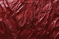 A crinkled satin fabric texture background in deep ruby red. The glossy, textured surface adds depth