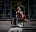 Cripple basketball player in a wheelchair holds a ball on an open gaming ground.