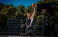 Cripple basketball player in a wheelchair holds a ball on an open gaming ground. Royalty Free Stock Photo