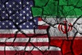 Crisis and confliction concept of america and iran . flags on cracked ground background