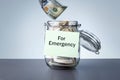 For Emergency written on a jar with dollars banknotes money