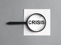 Crisis inscription on paper through magnifier on gray