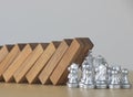 Crisis management, risk management, crisis solving or problem solving concept. Chess stopping wooden dominoes from collapsing Royalty Free Stock Photo