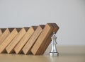 Crisis management, risk management, crisis solving or problem solving concept. King chess stopping wooden dominoes from collapsing Royalty Free Stock Photo