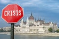 Crisis stop sign with view of parliament in Budapest, Hungary. Financial crash in world economy because of coronavirus pandemic.