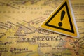 Crisis in Venezuela concept with caution sign placed over country map Royalty Free Stock Photo