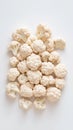 Crisp cauliflower florets arranged symmetrically on pristine white surface, highlighting vegetable's clean texture and Royalty Free Stock Photo