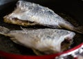 Crisp fresh Sea Bream fried in hot oil on skillet