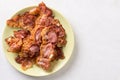 Crisp fried bacon on the plate above white marble background table