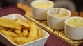 Crisp rustic fries served on a tray with three sauce bowls