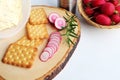 Crispbread with butter and sliced radish on wooden cutting board.