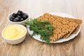 Crispbread and dill in plate, bowl with mayonnaise and olives