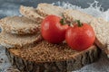 Crispbread, tomatoes and raw buckwheat on wooden piece