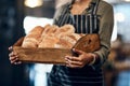 The crispiest buns around town. a woman holding a selection of freshly baked breads in her bakery. Royalty Free Stock Photo