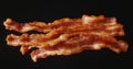 Crispy Bacon Slices on Black Background, Appetizing Food, Protein Royalty Free Stock Photo