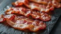 Crispy bacon slices on a black slate background. Royalty Free Stock Photo