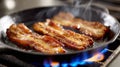 Crispy bacon strips frying in a pan over a flame. Royalty Free Stock Photo