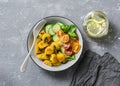 Crispy baked slices of polenta with sage butter and vegetables cucumbers, tomatoes, basil salad on a gray background, top view. Royalty Free Stock Photo