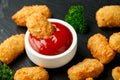 Crispy Battered scampi nuggets with ketchup and mayonnaise on rustic stone board.